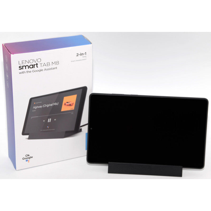 A Lenovo smart TAB MB 2-in-1 tablet with Google Assistant shown standing on a black stand next to its retail box on a white background.