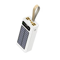 A white portable power bank with a built-in solar panel on the front, featuring two gold USB-A ports and one USB-C port on the top, complete with a carrying loop.