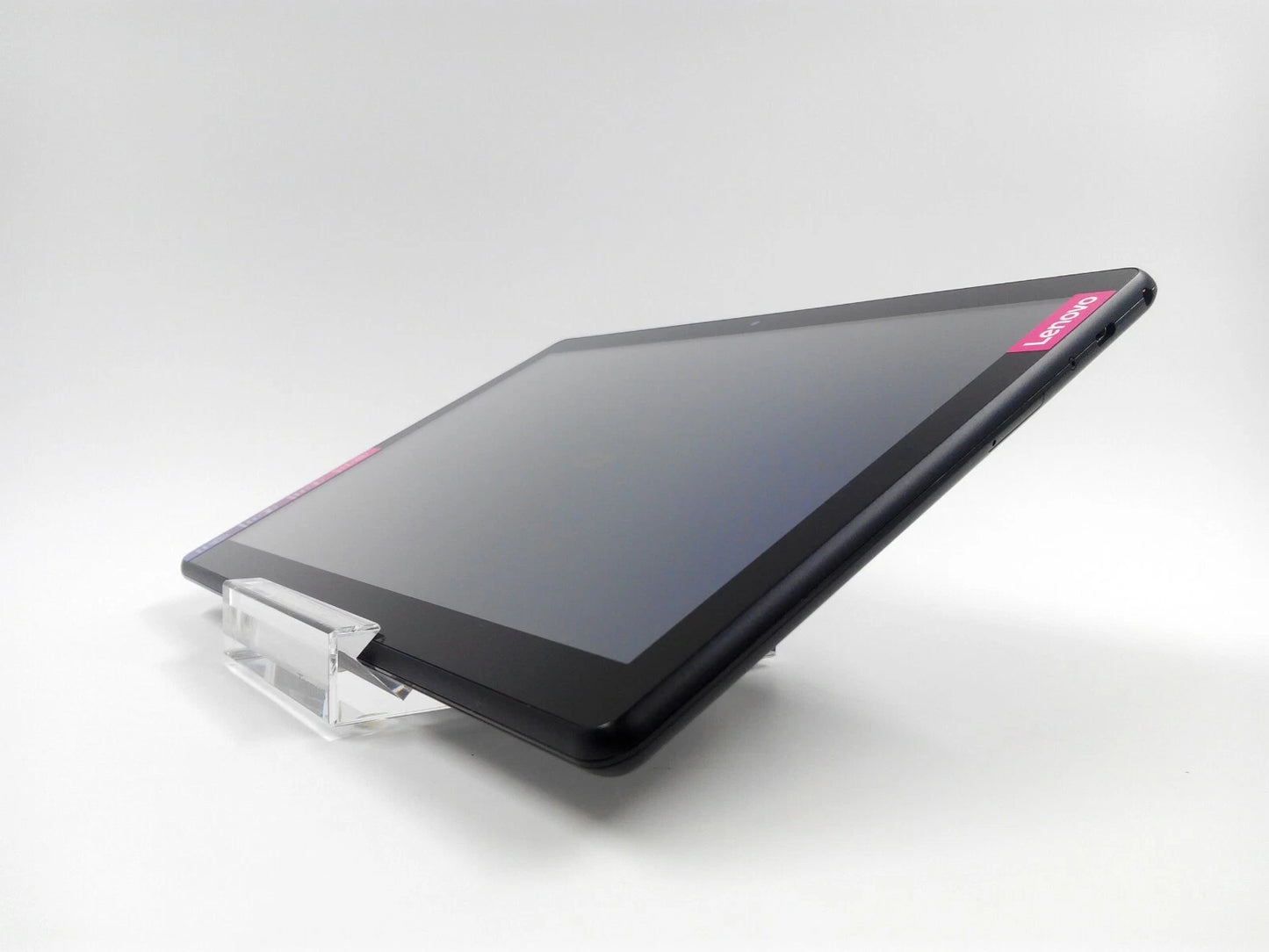 A black Lenovo tablet resting on a clear acrylic stand against a light gray studio background.